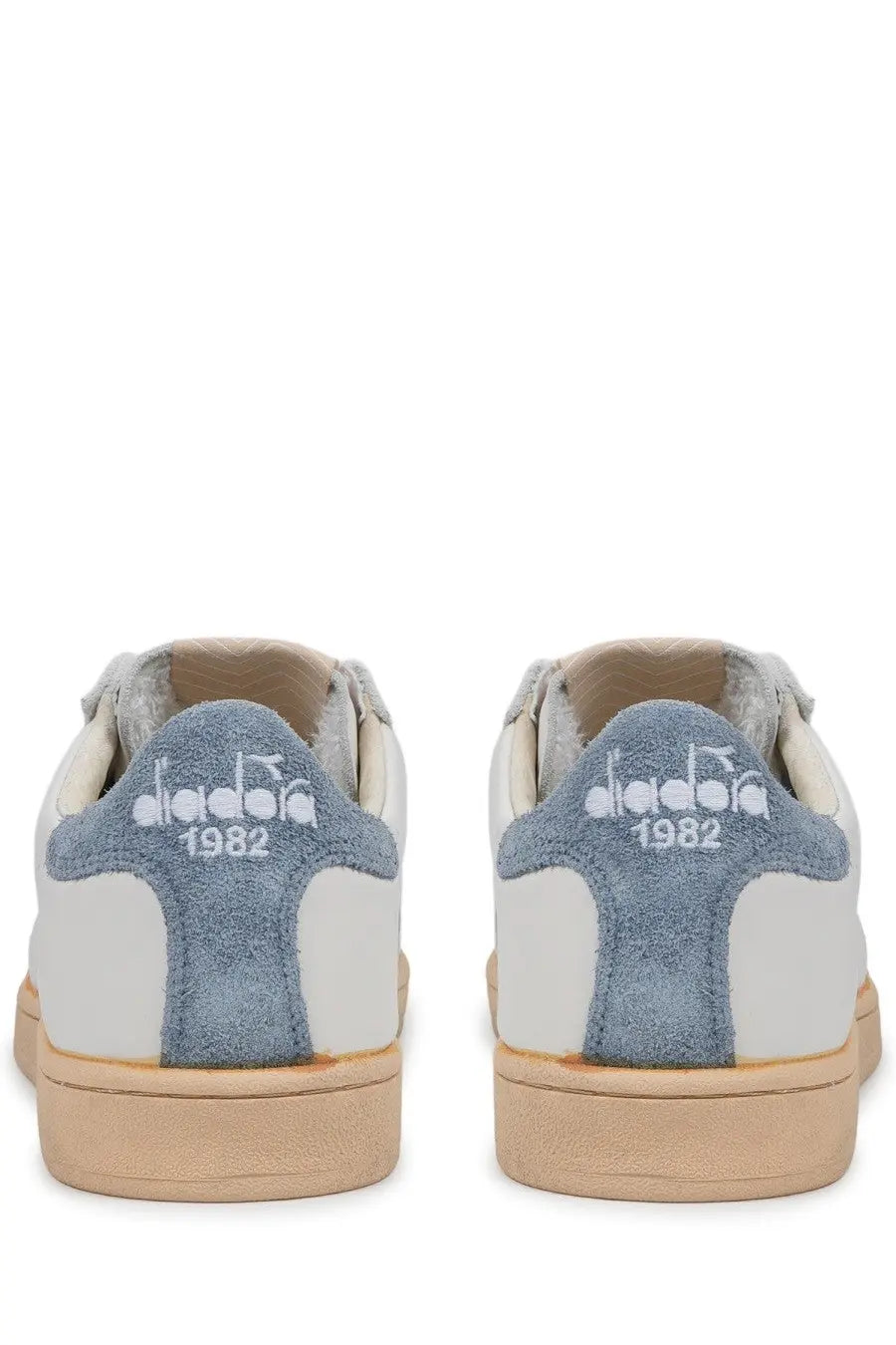 Back side of white and blue suede diadora men’s sneaker prestige plain used with vintage 1982 logo on heel