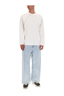 White long-sleeved crewneck sweatshirt with subtle seams and small logo paired with diesel men’s enim jeans blue