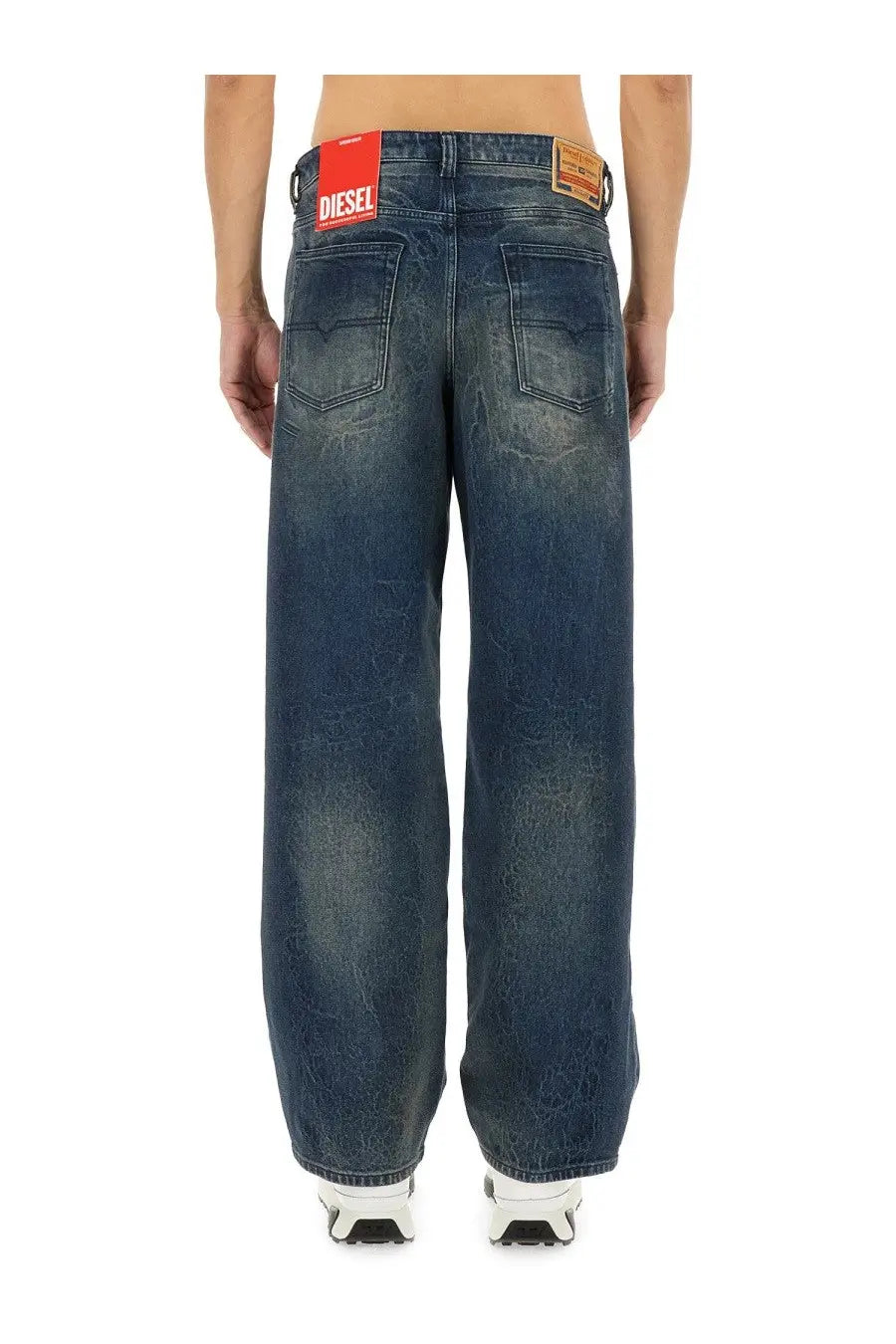 Dark blue denim diesel men’s jeans with a faded cracked wash and red brand label on the back waistband
