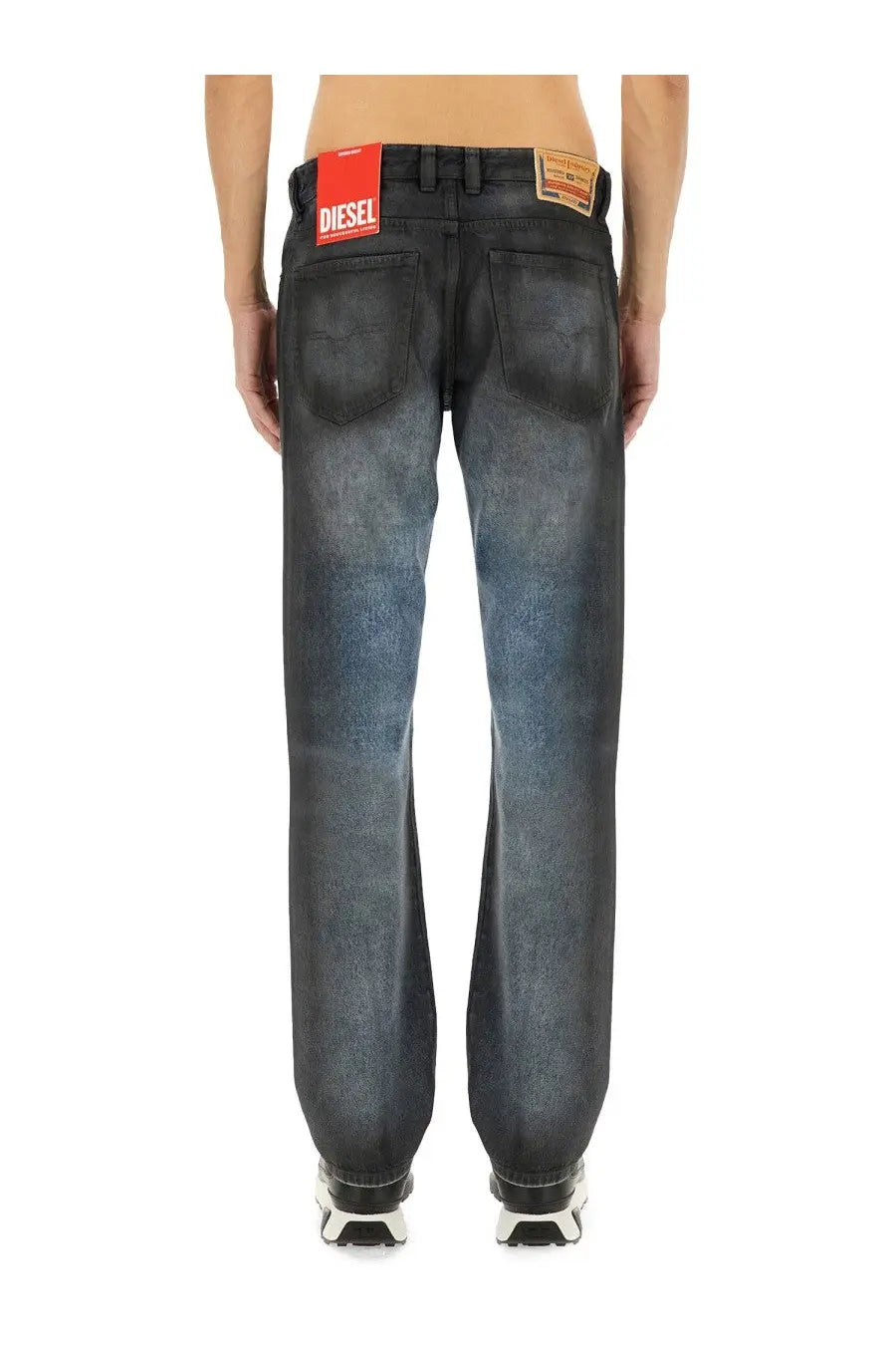 Back view of diesel men’s dark-wash denim jeans with faded distressed look and red brand label on waistband