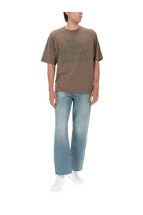Brown short-sleeved t-shirt with faded green graphic print paired with diesel men’s jeans eeper blue