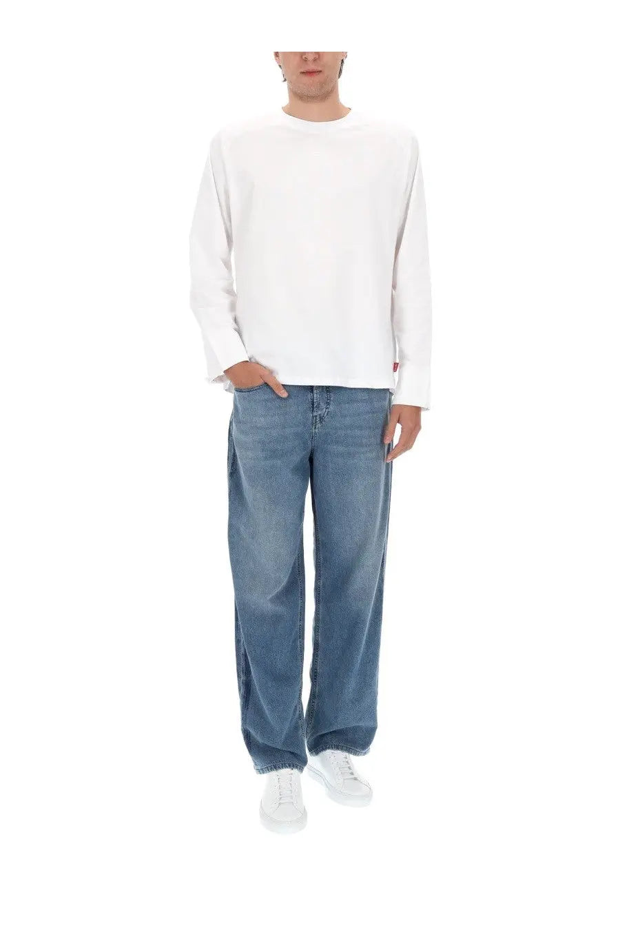 White long-sleeved crewneck sweatshirt with small red tag on left sleeve paired with diesel men’s jeans macro blue