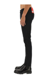 Back view of diesel men’s strukt black slim fit jeans with a red brand tag on the waistband