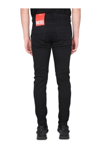Back side of diesel men’s jeans strukt black slim fit black denim with a red brand label on the waistband