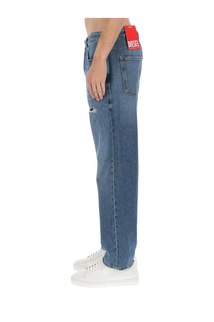 Diesel men’s Macs blue denim jeans with distressed knee patch and red Diesel brand tag at the waistband