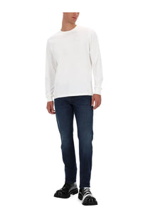 Diesel men’s white long-sleeved crewneck sweater paired with dark blue jeans casual outfit look