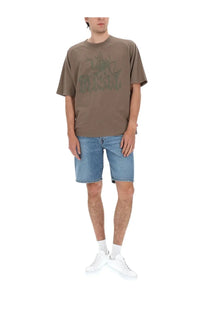 Olive green oversized t-shirt with faded graphic print paired with diesel men’s denim blue shorts in a casual look