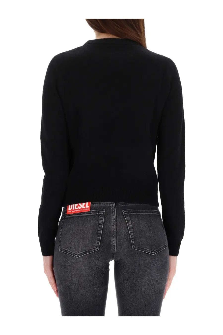Back view of diesel women’s areesa black long-sleeved knit sweater with red logo patch on lower back