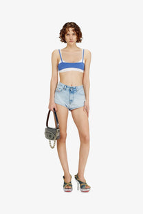A small structured gray leather handbag with chain strap and metallic hardware paired with diesel blue denim shorts