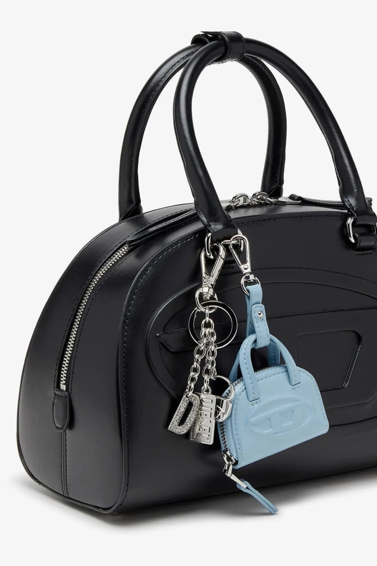 Black glossy leather handbag with curved handles and a light blue diesel dome charms pvc keychain attached front