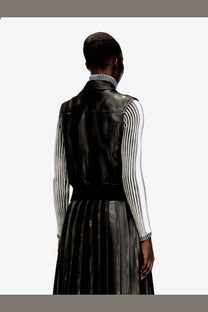 Diesel women’s Inko black faux leather sleeveless jacket with vertical stitching and high collar worn over striped shirt