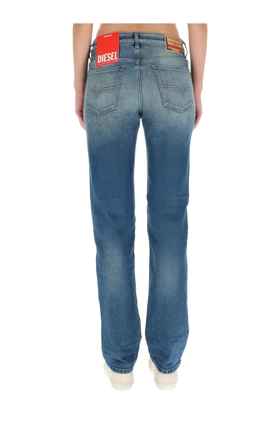 Back side of diesel women’s mine blue denim jeans with faded wash and red brand label on waistband