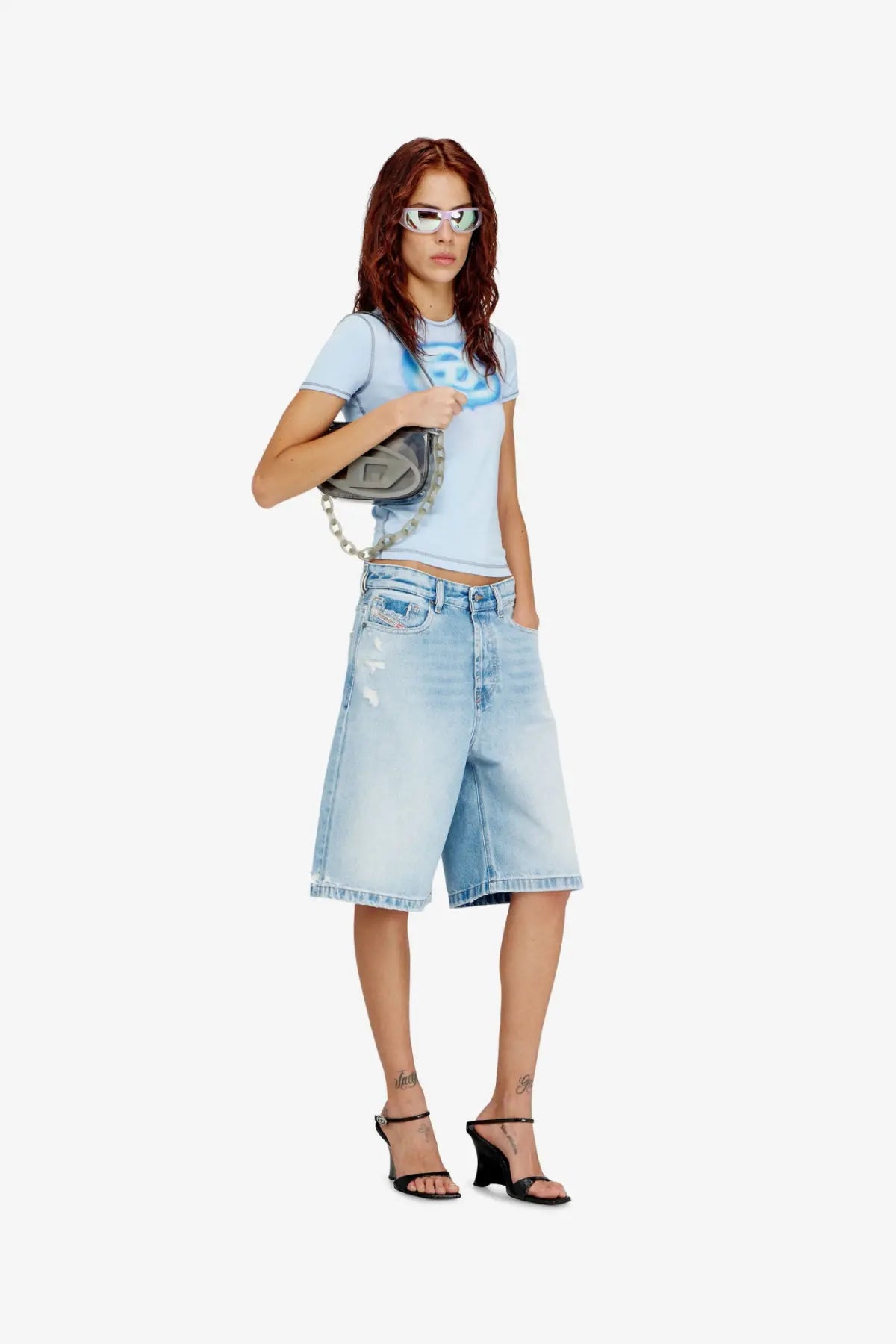 Diesel women’s tpu shoulder bag in black with light blue denim shorts featuring faded wash and distressed details