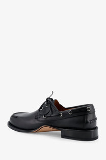 Dior men’s Archie leather loafers in black featuring silver eyelets and a contrasting tan insole