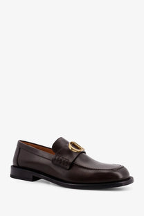 Dior men’s archie leather loafers in brown with gold tone circular buckle on brown leather upper