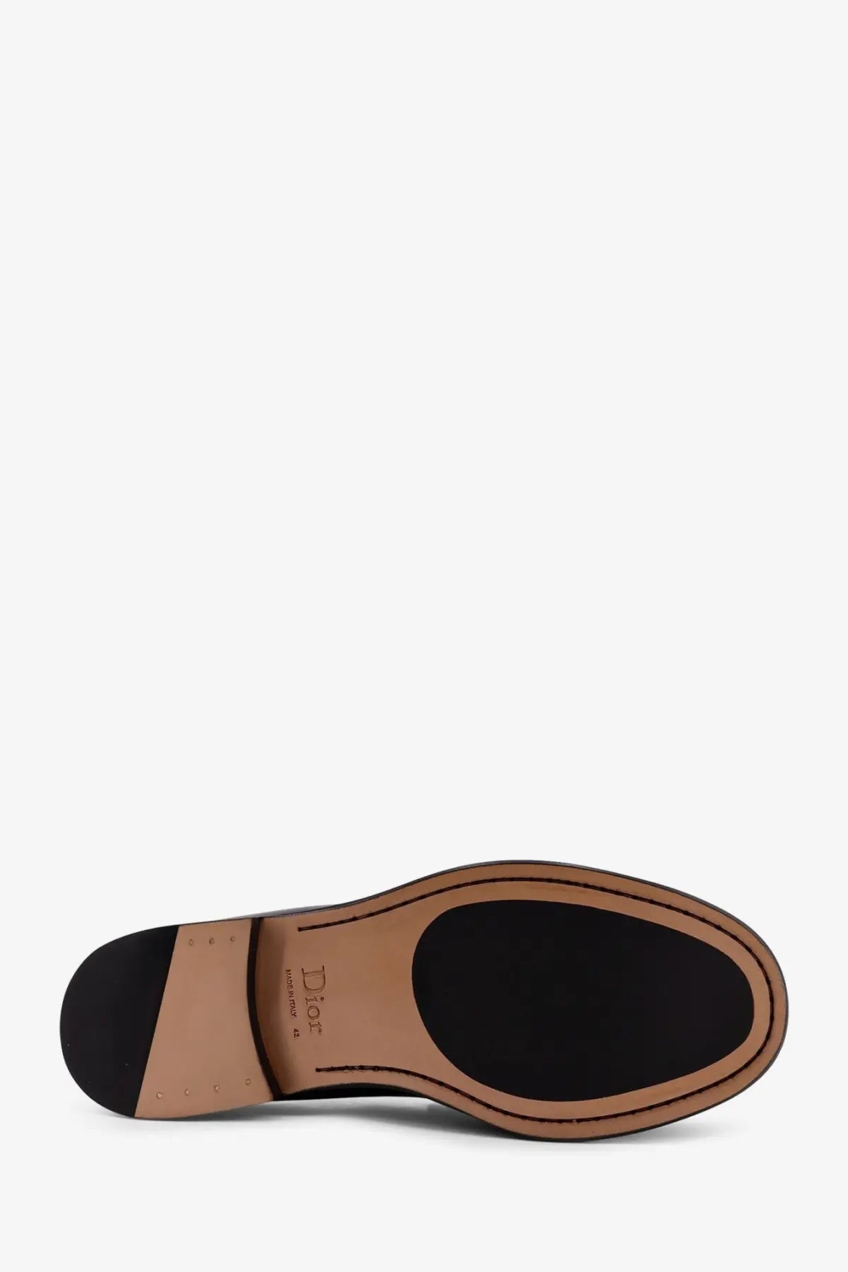 Back view of dior men’s black leather loafers showing sole with tan rubber heel and black circular patch