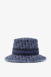 Blue denim bucket hat with repeating dior logo pattern and black ribbon band from dior women’s bobby dior oblique cloche blue collection