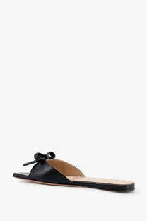 Black leather slide sandal by Dior for women featuring a front bow detail in classic black color