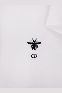Black embroidered bee logo with cd initials on white cotton fabric of dior womens cotton shirt front side