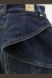 Dark blue denim Dior women’s draped flared jeans with contrasting stitching and Dior brand label visible