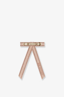 A delicate blush pink Dior women’s Fiocco hair clip with gold-tone metal clasp and subtle glittery texture