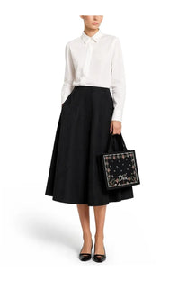 Black dior tote bag with embroidered floral pattern and brand logo paired with dior women’s white shirt