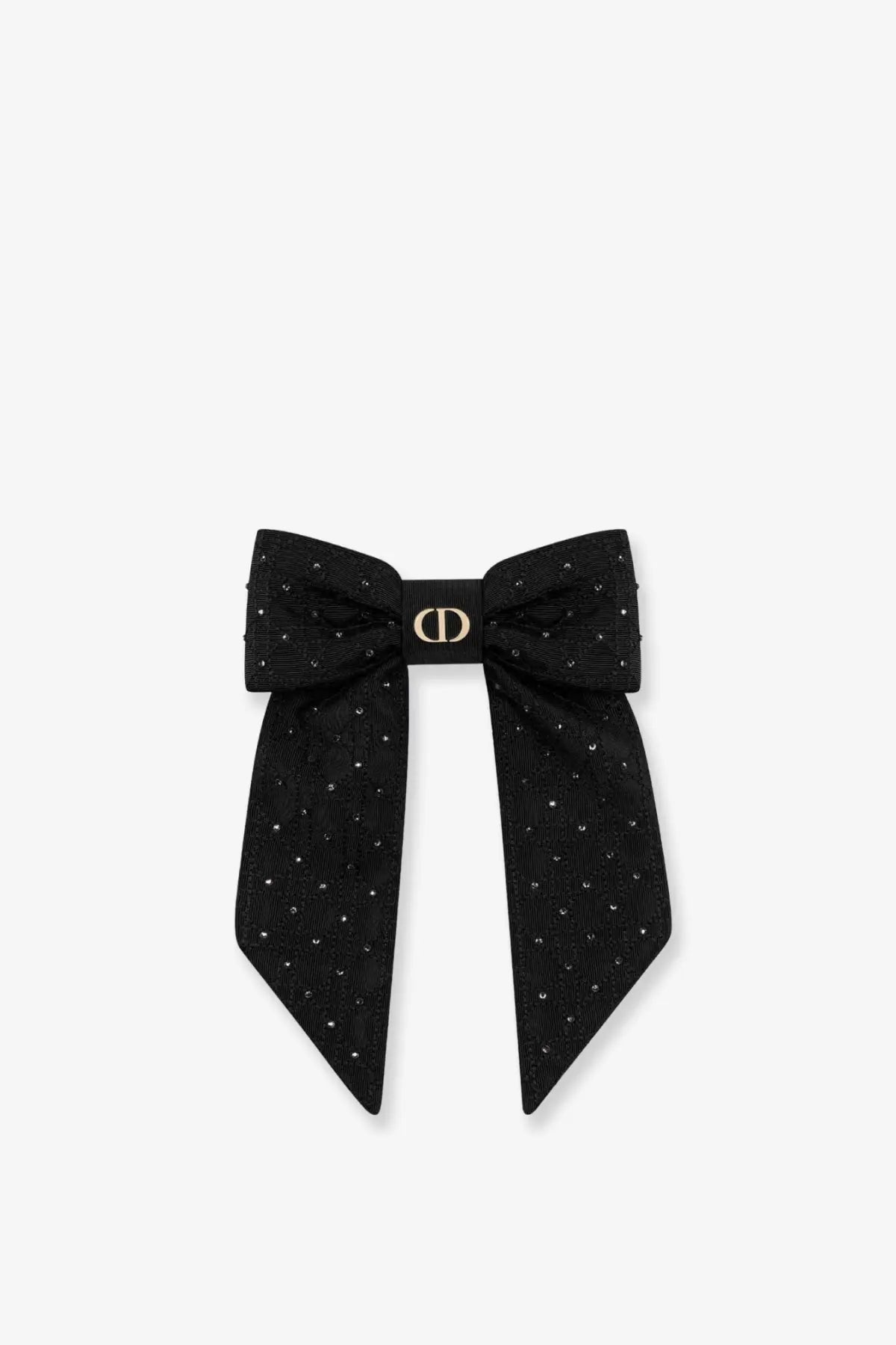 Black dior bow clip with silver colored crystals and a gold tone logo centerpiece made from technical fabric