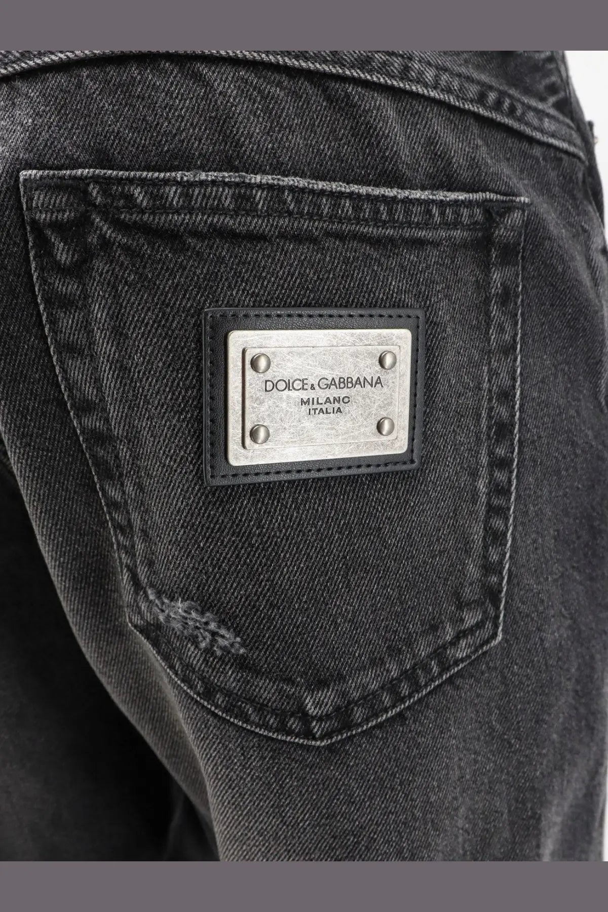Dolce &amp; Gabbana men’s black denim trousers featuring a silver metal plaque engraved with dolce &amp; gabbana milano italia