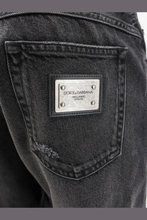 Dolce &amp; Gabbana men’s black denim trousers featuring a silver metal plaque engraved with dolce &amp; gabbana milano italia