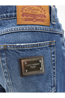Back side of dolce and gabbana men’s blue denim jeans with brown leather patch and metallic plaque on back pocket
