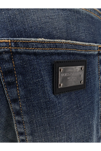 Dark blue denim jeans with black leather patch and silver dolce and gabbana logo plaque on the back side