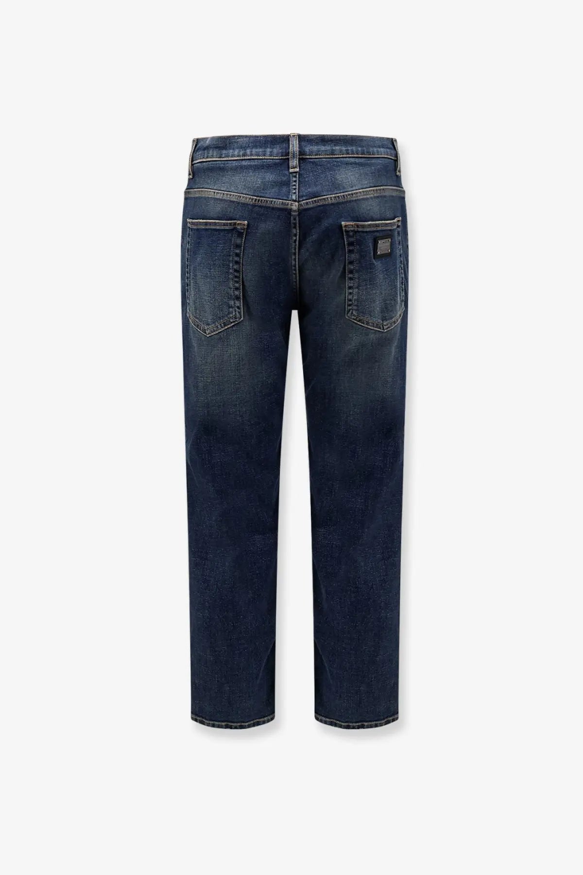 Dark blue dolce &amp; gabbana men’s denim jeans with faded wash and stitched back pockets visible from the back side