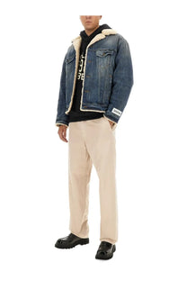 Blue denim jacket with cream-colored shearling lining and white label on left sleeve shown with dolce &amp; gabbana beige cotton pants