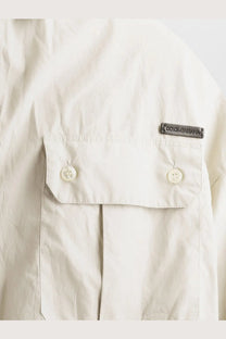 Dolce &amp; Gabbana men’s beige cotton shirt pocket with two buttons and metallic brand tag visible on front side