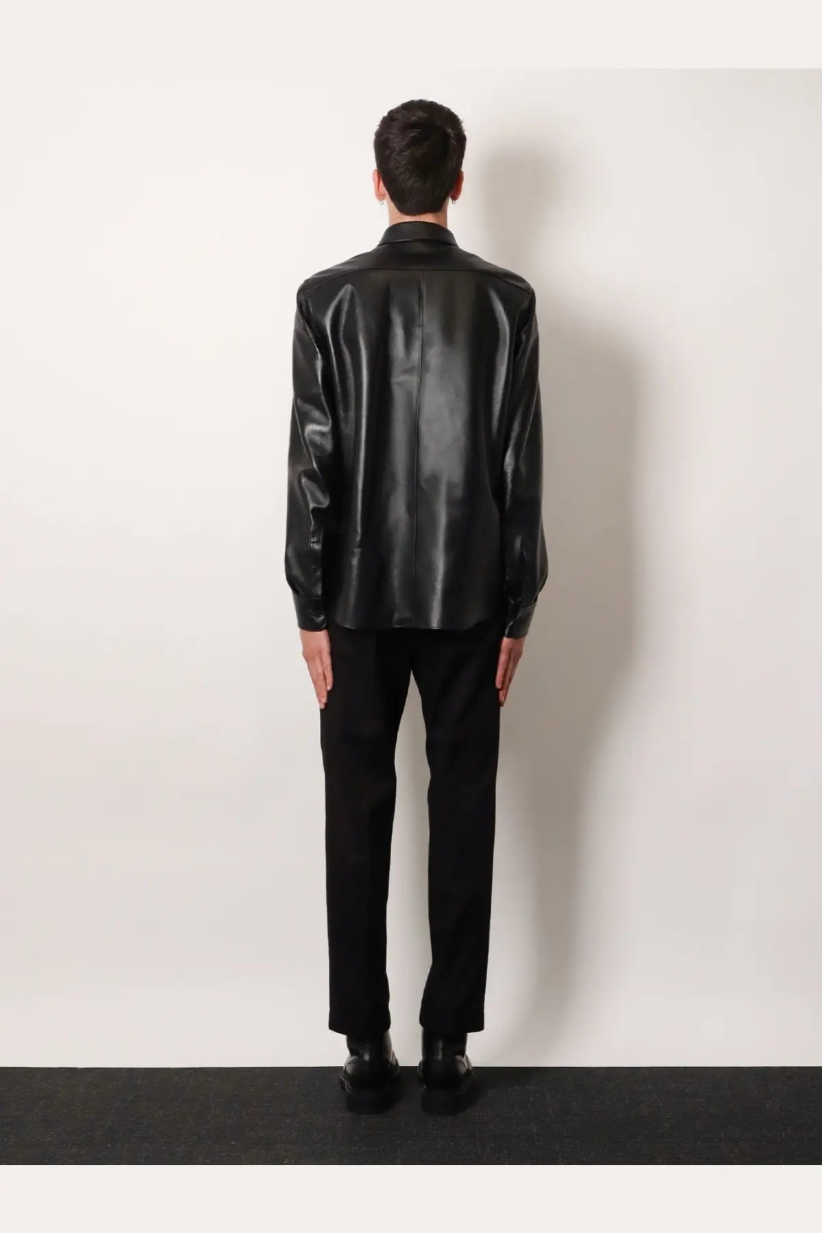 Black glossy faux leather shirt with classic collar and long sleeves paired with dolce &amp; gabbana men’s black cotton trousers