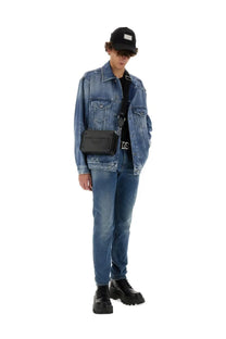 Black rectangular crossbody bag with embossed branding and silver hardware paired with dolce and gabbana blue denim shirt