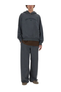 Dark gray dolce &amp; gabbana men’s hoodie with subtle arched logo across chest paired with grey jogging pants