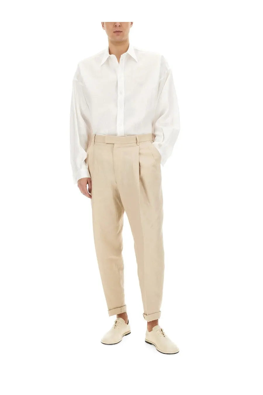 A pair of beige pleated trousers with tailored fit and rolled cuffs styled with a dolce &amp; gabbana men’s white linen shirt
