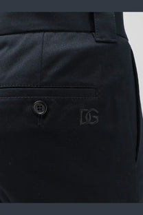 Black dg logo embroidered on the front pocket of dark navy cotton chino pants from dolce and gabbana men’s trousers