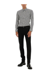A man wearing a dolce and gabbana men’s gold multicolor shirt in black and white stripes with slim-fit black trousers