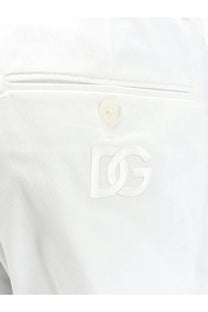 White dolce and gabbana dg logo patch on the white fabric pocket of men’s stretch cotton trousers