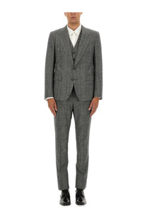 A man wearing a Dolce &amp; Gabbana men’s three piece grey checkered suit with matching trousers and a white dress shirt