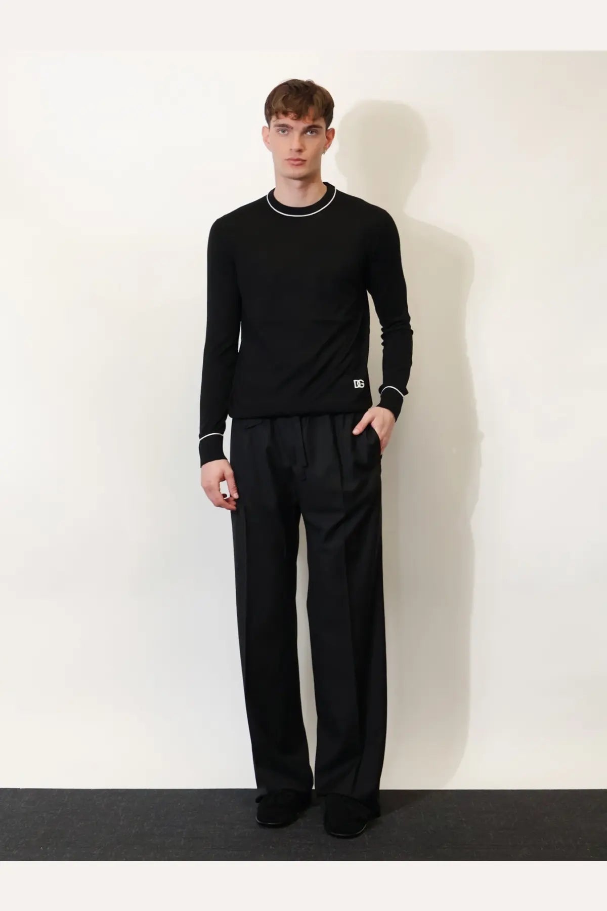 Dolce and Gabbana men’s black virgin wool sweater with white ribbed trim and small dg logo on left chest