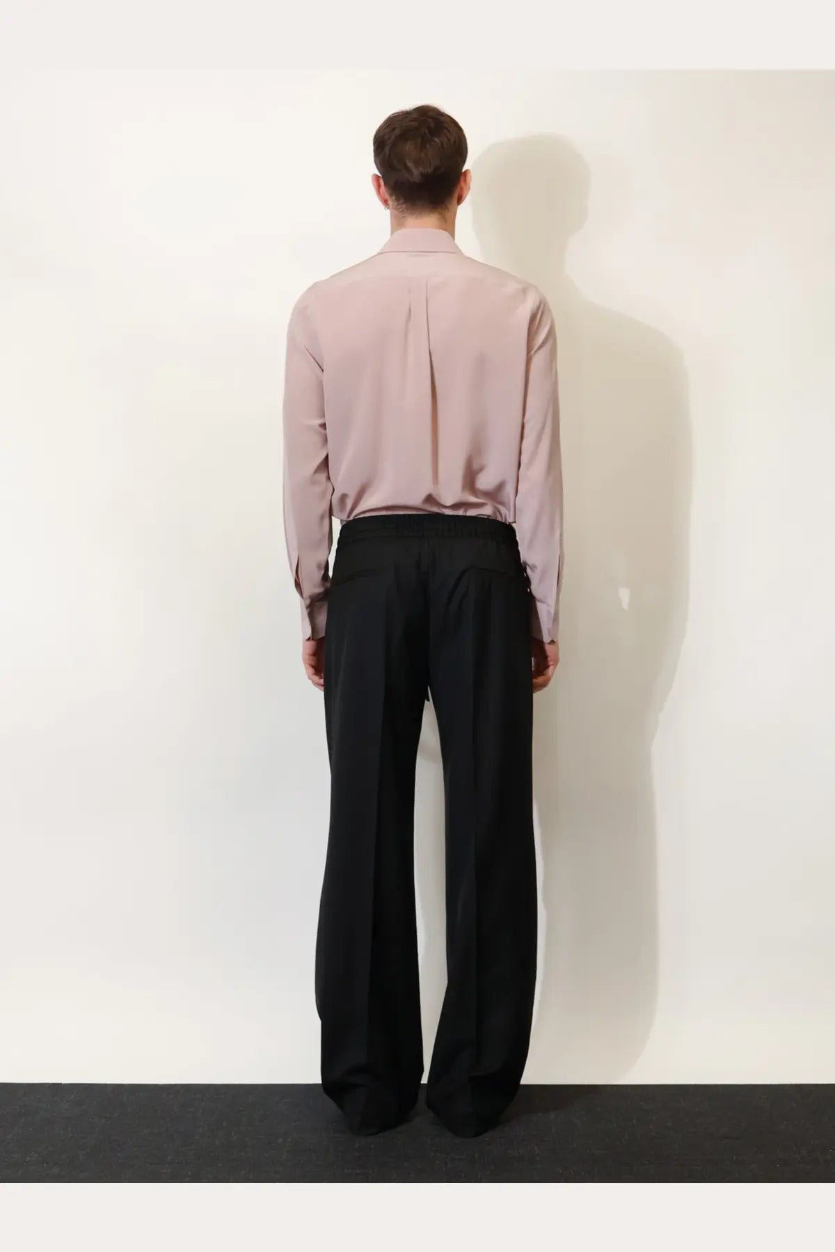 Dolce &amp; Gabbana men’s black virgin wool wide-leg trousers with tailored fit and subtle back pleats shown from back