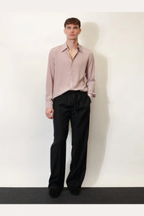 A soft blush pink long-sleeved button-down shirt with a classic collar paired with dolce &amp; gabbana men’s black virgin wool trousers