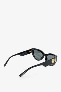 Dolce &amp; Gabbana women’s black acetate cat-eye sunglasses with gold lion head embellishments and dark gray lenses