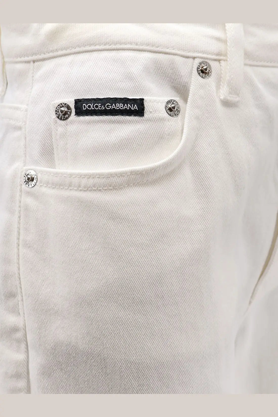 Dolce &amp; Gabbana women’s Audrey white denim trousers with silver metal buttons and black brand label visible