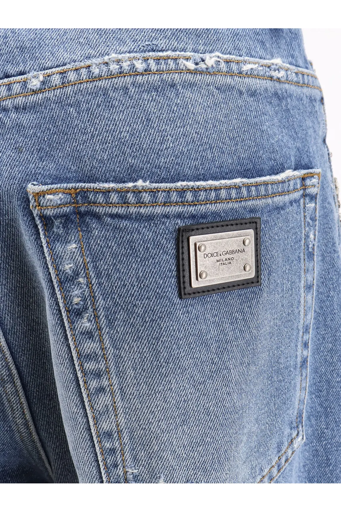 Back side of dolce and gabbana women’s blue denim jeans with distressed pocket and silver-tone milano italia label