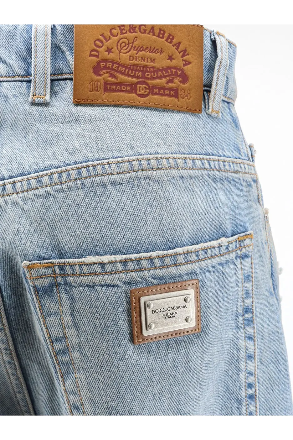 Back side of dolce and gabbana women’s light-wash blue denim jeans with brown leather patch and metallic pocket plaque