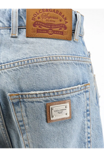 Back side of dolce and gabbana women’s light-wash blue denim jeans with brown leather patch and metallic pocket plaque